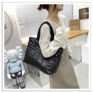 Vista dettagliata della borsa tote trapuntata in nylon nero con finitura lucida