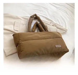Gros plan sur le sac fourre-tout matelassé marron foncé avec étiquette en cuir mode