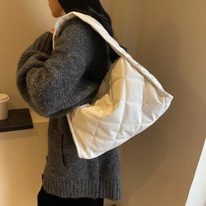 Detail of white quilted puffer shoulder bag with soft padding and rhombus stitching pattern