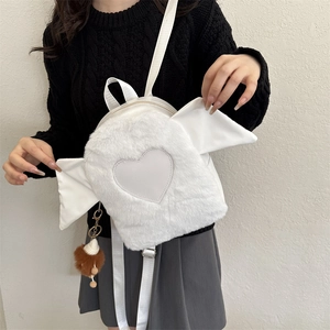 Detail of white plush backpack featuring heart patch and distinctive wing design elements