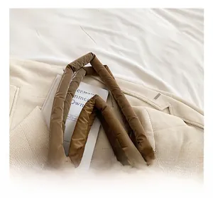 Dettaglio della borsa tote trapuntata caramello con manici morbidi e trama in nylon