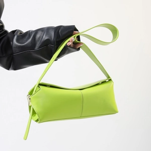 Dettaglio della borsa geometrica in pelle PU verde neon con tracolla regolabile
