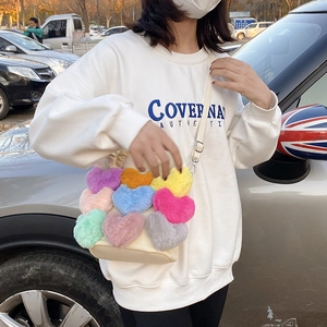 Détails d'un sac à bandoulière en peluche avec cœurs colorés et fausse fourrure douce de luxe