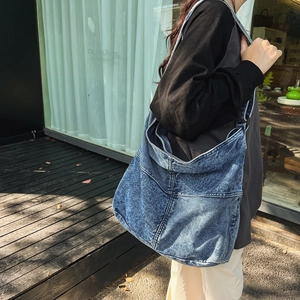 Vista dettagliata delle cuciture e della trama di una grande borsa a tracolla in denim