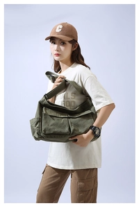Detail view of military green canvas messenger bag featuring vintage utility cargo pockets
