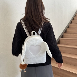 Close-up of white plush bunny ear backpack with heart patch on a model back