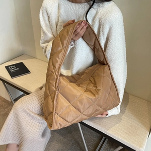 Detail of warm brown quilted puffer tote bag with spacious interior and wide shoulder strap