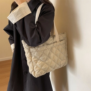 Gesteppte beige Nylon-Einkaufstasche mit Rautenmuster, am Modell getragen