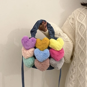 Vue détaillée du sac en jean avec cœurs en peluche colorés et bandoulière en denim