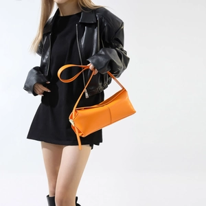 Borsa a spalla rettangolare minimalista in pelle arancione brillante indossata da modella