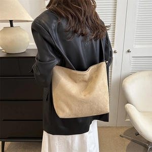 Rückansicht einer minimalistischen khakifarbenen Shopper-Tasche aus Wildleder am Model