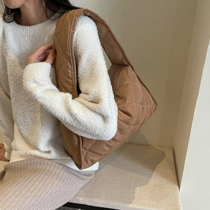 Detailed close-up of brown quilted nylon hobo bag showing classic diamond stitching textures