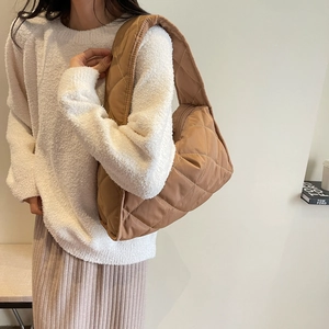 Caramel brown quilted tote bag with diamond stitching shown on model in a modern style
