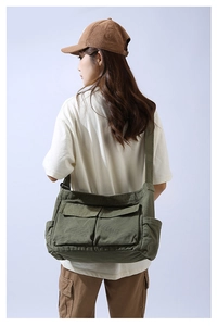 Detailed back view of army green canvas crossbody bag showing large capacity and strap