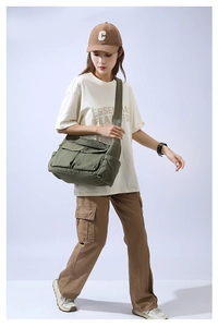 Detail of dark green canvas crossbody bag with dual utility pockets and spacious design