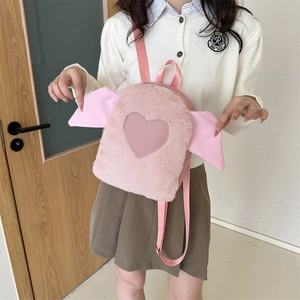 Close-up of pink plush backpack featuring leather heart and wing details for women