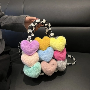 Détail du sac à main coloré en peluche avec coeurs et bandoulière à carreaux