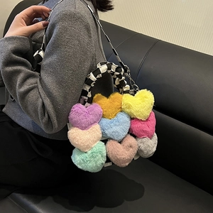 Détail du sac à main en peluche patchwork en forme de cœur avec anse à carreaux