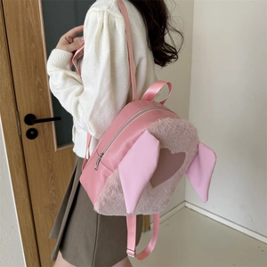 Detail of pink plush backpack with cute animal ears and heart pattern on the side