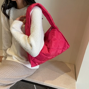 Macro view of quilted rose pink hobo bag with padded fabric and rhombus stitching texture