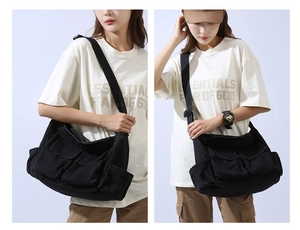 Detail of large black canvas messenger bag featuring multiple pockets and adjustable strap