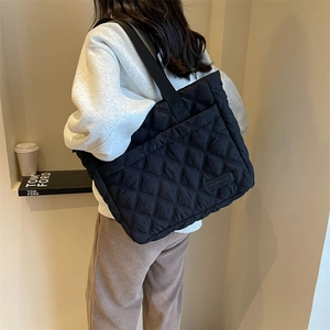 Minimalistische schwarze gesteppte Tote Bag mit Rautenmuster und breitem Schultergurt