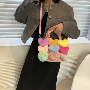 Détail du sac rose avec neuf cœurs en peluche colorés et des finitions métalliques argentées
