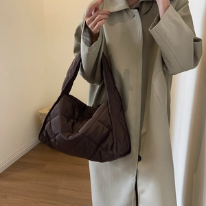 Detail of dark brown quilted hobo bag with puffer design and wide shoulder strap