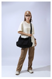 Detail of black large capacity canvas crossbody bag with dual front flap pockets