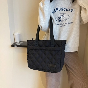 Detail der schwarzen gesteppten Shopper-Tasche mit Rautenmuster und Nylon-Material