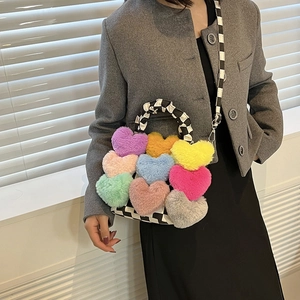 Détail d'un sac à damier orné de cœurs en peluche multicolores et d'une bandoulière