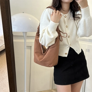 Gros plan du sac hobo en toile marron montrant le détail de la bandoulière plissée