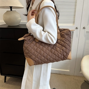 Détail du sac cabas matelassé marron avec coins en cuir renforcés et bretelles souples