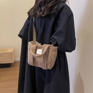 Gros plan du sac cabas marron en peluche avec écusson logo et bandoulière tissée