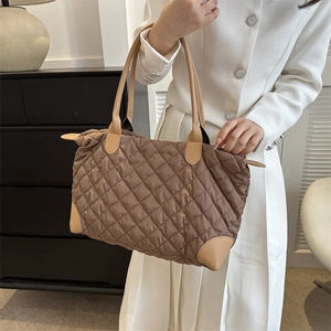 Vue détaillée du sac cabas matelassé marron avec poignées en cuir et texture en nylon