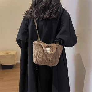 Sac bandoulière en peluche marron avec étiquette EDI PLAN porté par un mannequin