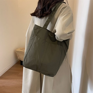 Olive green nylon tote bag featuring spacious outer pocket and high-quality matte finish