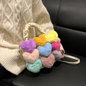 Détail de motifs cœurs en peluche colorés sur un sac bandoulière porté par un mannequin