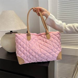 Détail du sac fourre-tout en nylon rose matelassé avec coins renforcés en simili cuir