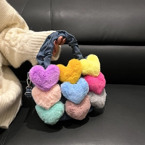 Détail de cœurs en peluche colorés sur un sac en denim bleu avec anse froncée