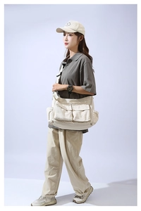 Detailed shot of beige large capacity canvas crossbody bag with multi-pocket design