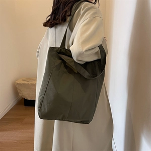 Detail of army green nylon tote bag showing spacious capacity and water-resistant texture