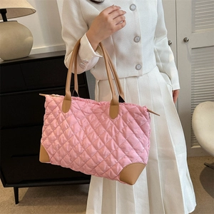 Vue détaillée du sac cabas matelassé en nylon rose avec anses en cuir marron sur mannequin