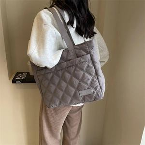 Makroansicht der grauen Stepp-Tote-Bag mit klassischer Rautensteppung und breitem Gurt