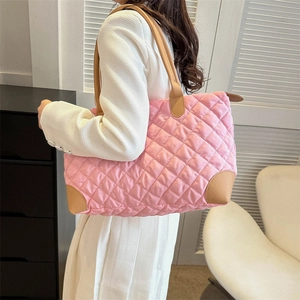 Sac cabas rose matelassé en nylon avec anses en cuir présenté dans un décor quotidien