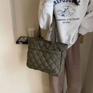 Detailansicht der olivgrünen gesteppten Nylontasche mit Fronttasche und Lederetikett
