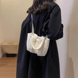 Détail d'un sac bandoulière blanc en laine d'agneau avec étiquette Hilldi Plan