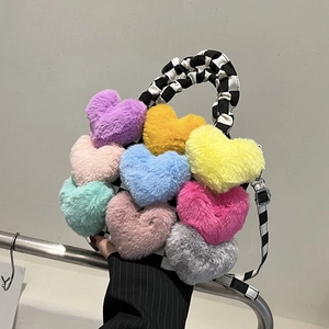 Détail du sac à main en peluche avec cœurs colorés, anse à carreaux et boucles argentées