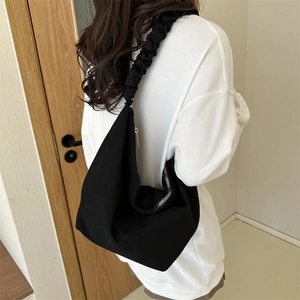 Sac à épaule minimaliste en toile noire avec bandoulière plissée et fermeture éclair