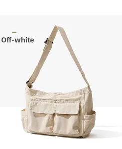Detailed front view of a beige canvas messenger bag with dual pockets and adjustable strap
